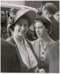 1950 photo of the future queen and her sister Margaret at the Derby horse race, with a papr caption caption and ‘Barratt’s Photo Press’ stamp on the back.